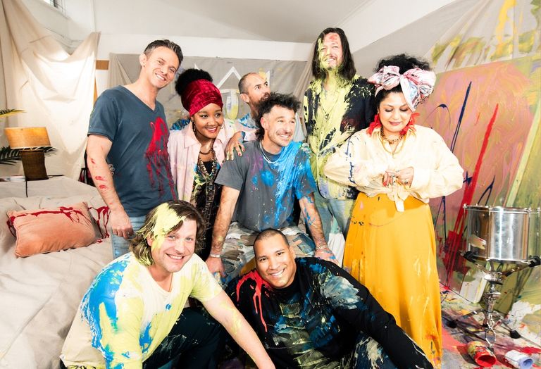 Australian band The Cat Empire members covered in colourful paint posing together in an art studio captured by Giulia McGauran